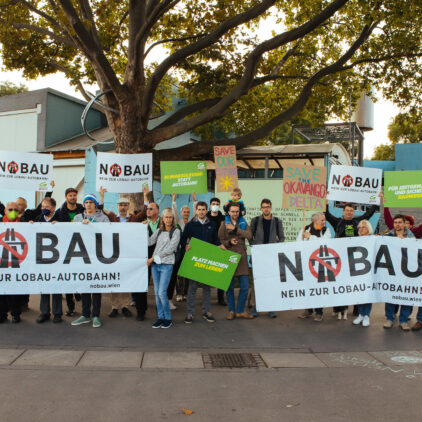 Menschen mit "Nobau"-Schildern und Bannern demonstrieren gegen den geplanten Lobautunnel