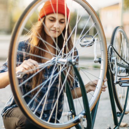 Eine junge Frau repariert ein Fahrrad