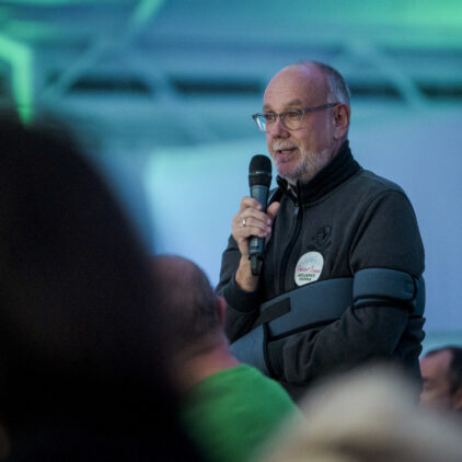 Ein Mann aus dem Publikum spricht in ein Mikrofon