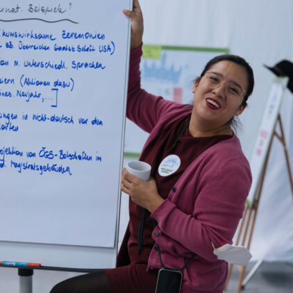 Foto einer Teilnehmerin bei Influence Vienna mit einer beschriebenen Tafel