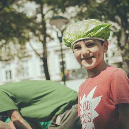 Foto eines Kindes, das eine grüne Haube trägt