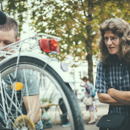 Foto einer Frau, die bei einer Fahrradreparatur zusieht