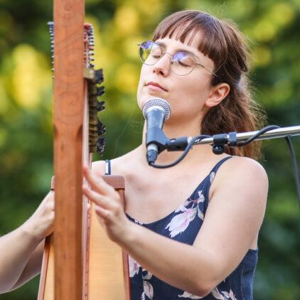 Eine junge Frau spielt auf der Harfe
