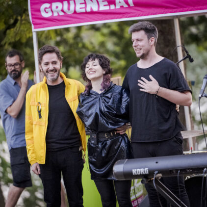 Drei Musiker:innen stehen auf der Bühne