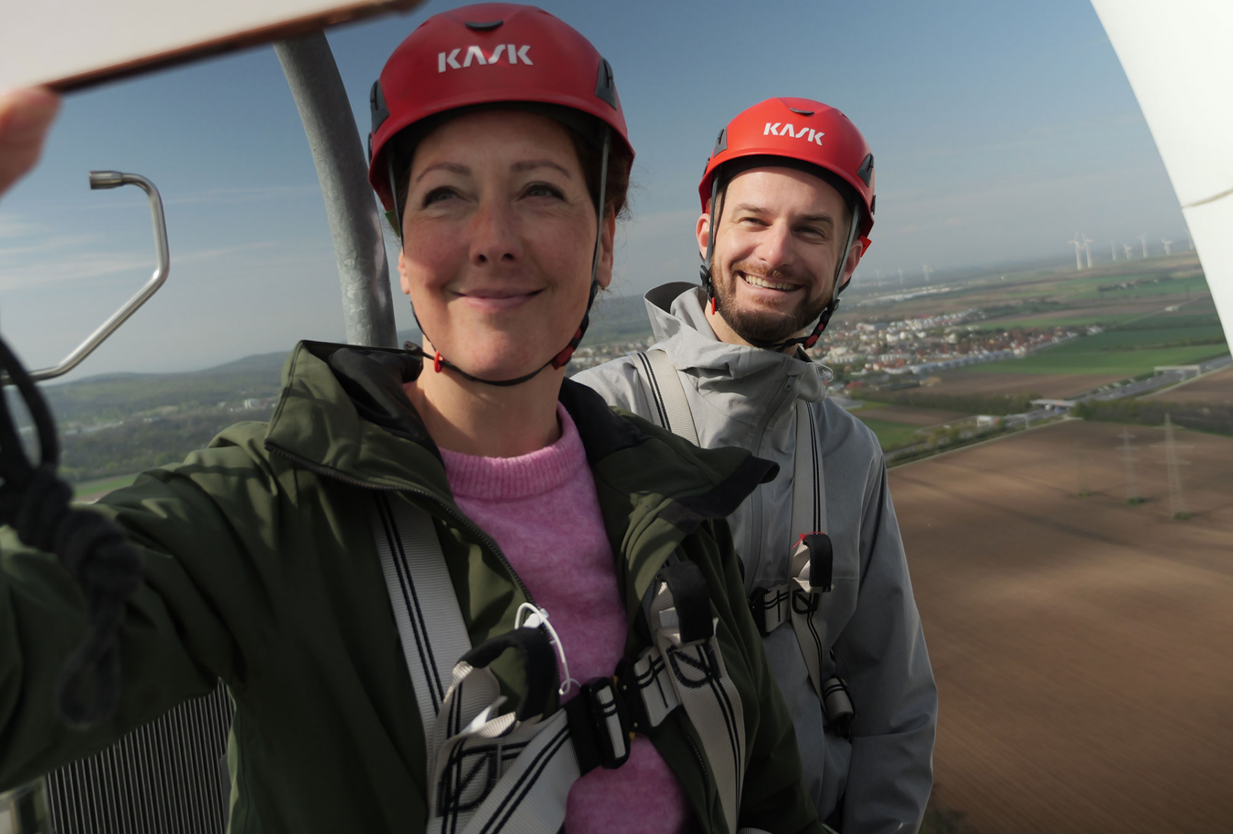 Foto von Judith Pühringer und Peter Kraus, die auf einem Windrad stehen und ein Selfie fotografieren