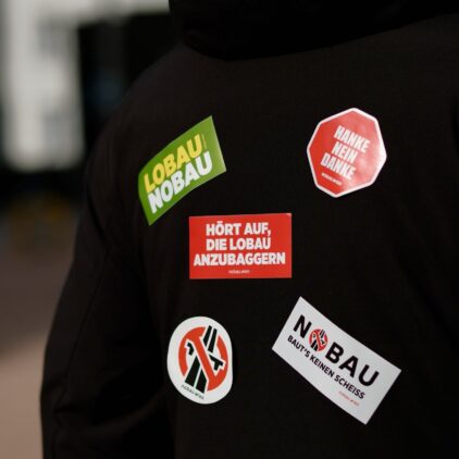 Rücken einer Person, beklebt mit 5 Nobau-Stickern